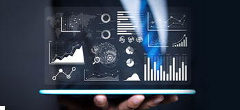 Person holding a tablet displaying multiple data visualizations, including bar charts, line graphs, pie charts, and network diagrams, with a dark background.